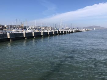 Pier over sea against sky in city