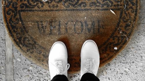 Low section of man standing on doormat