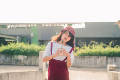 Full length of young woman holding mobile phone