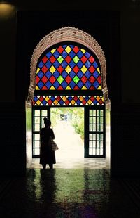 Silhouette woman seen through window