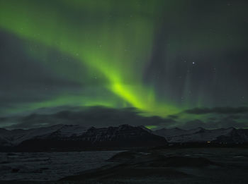 Scenic view of snowcapped mountains against sky at night