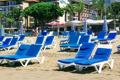 Chairs on beach against blue sky