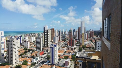 Aerial view of cityscape against cloudy sky