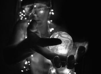 Close-up of hands holding illuminated lamp