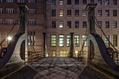 View of footbridge against building at night