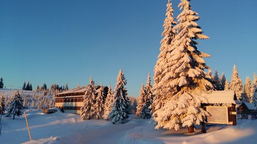 Built structure on snow covered landscape against clear blue sky