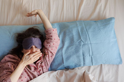 High angle view of woman lying on bed at home