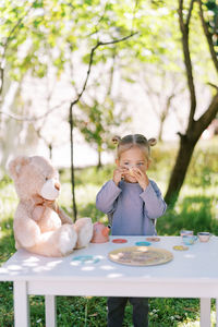 Portrait of boy playing with stuffed toy while sitting on table