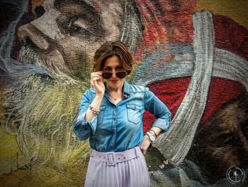 Full length of young woman standing on wall