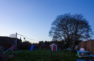 Bare trees against clear blue sky