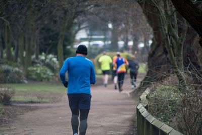 Rear view of man walking on footpath