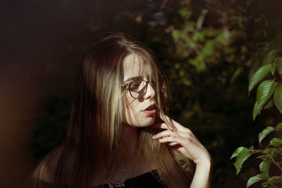 Beautiful woman standing by plants outdoors