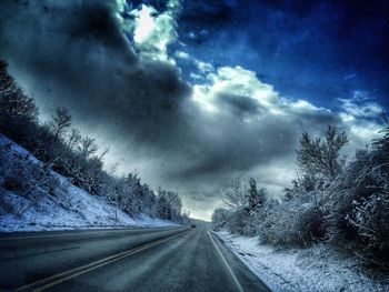 Empty road against cloudy sky