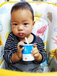 Close-up of cute baby boy on bed at home