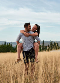 Full length of couple on field against sky