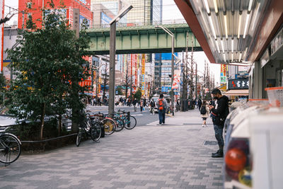 People on street amidst buildings in city