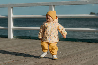 Full length of young woman walking on footbridge