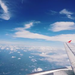 Airplane flying over clouds against sky