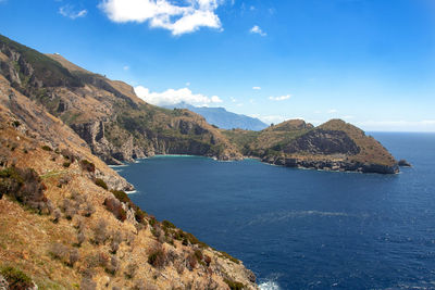 Scenic view of sea and mountains against sky