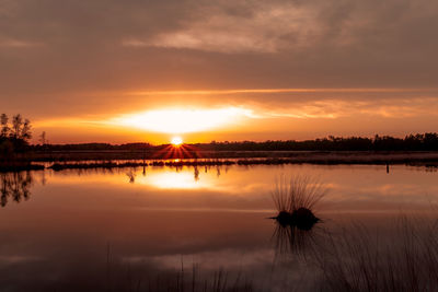 Scenic view of lake against sky during sunset