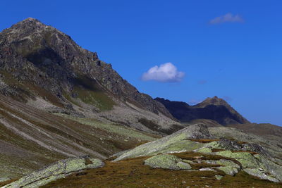 Scenic view of mountains against blue sky