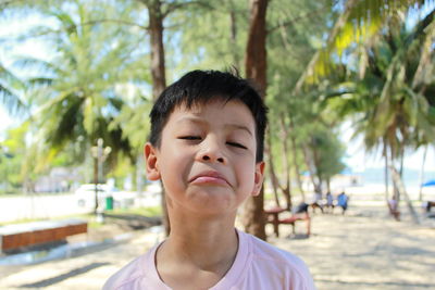 Portrait of sad boy standing at beach