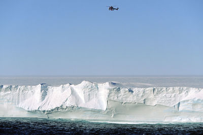 Helicopter over iceberg and sea