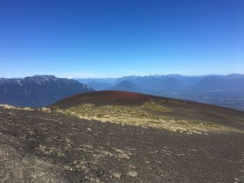 Scenic view of mountains against clear blue sky