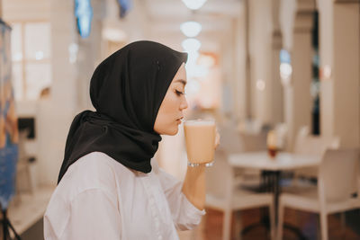 Side view of man holding coffee cup