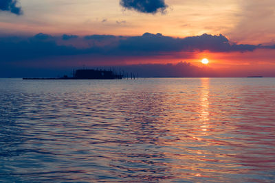 Scenic view of sea against romantic sky at sunset