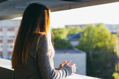 Side view of woman standing on balcony