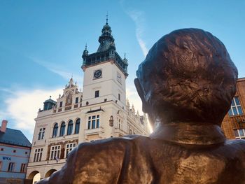 Low angle view of historical building against sky over a statue