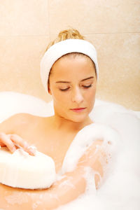 Woman bathing in bathtub at bathroom