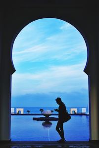 Silhouette man looking at sea against sky