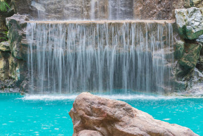 Landscape of beautiful artificial waterfall in garden at the public park.