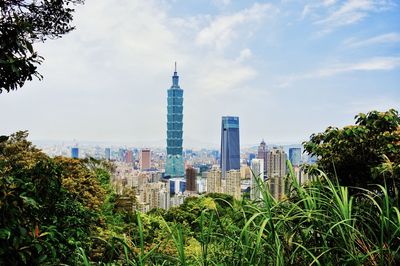 View of modern buildings against cloudy sky