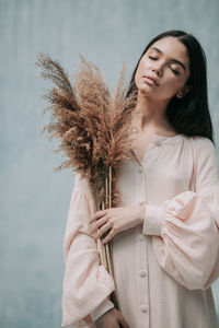 Young woman standing with palm tree