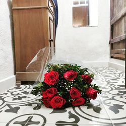 Red rose on table by window