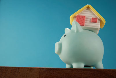 Close-up of piggy bank against blue background