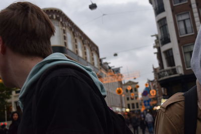 Rear view of people standing in city