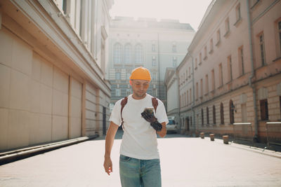 Full length of man standing on mobile phone in city