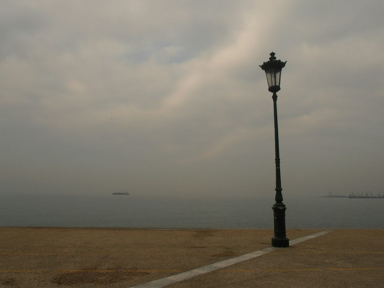 sea, water, sky, horizon over water, tranquility, street light, beach, tranquil scene, scenics, cloud - sky, beauty in nature, nature, shore, lighting equipment, idyllic, cloudy, cloud, outdoors, bird, sunset