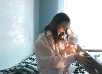 Young woman holding hands on bed