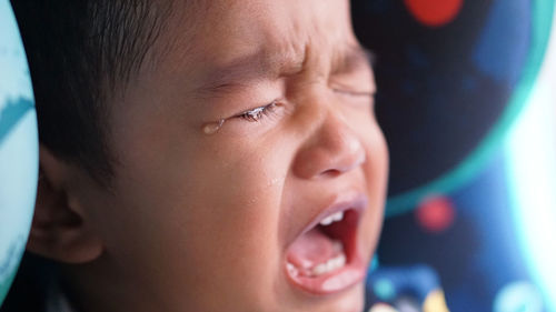 Close-up of baby boy crying in car