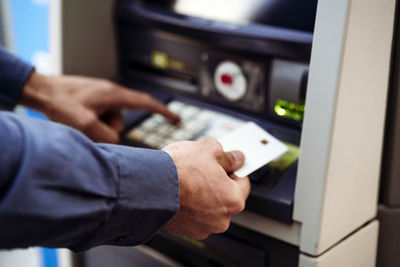 Businessman with credit card using atm machine