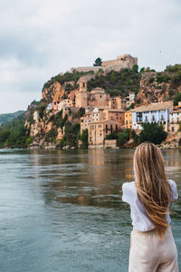 Rear view of woman looking at sea against sky