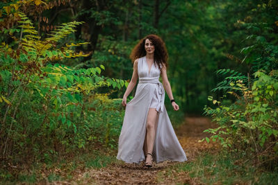 Full length of woman standing in forest