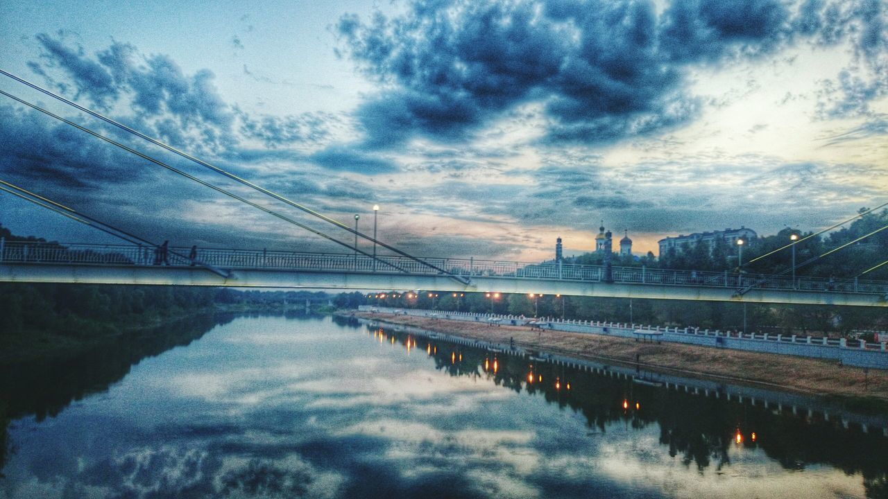 sky, water, cloud - sky, built structure, connection, architecture, reflection, river, bridge - man made structure, cloudy, cloud, weather, waterfront, dusk, nature, travel destinations, city, bridge, building exterior, tranquility