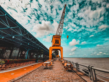 Crane at construction site against sky