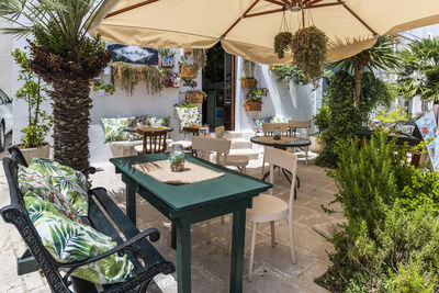 Chairs and tables in restaurant by building